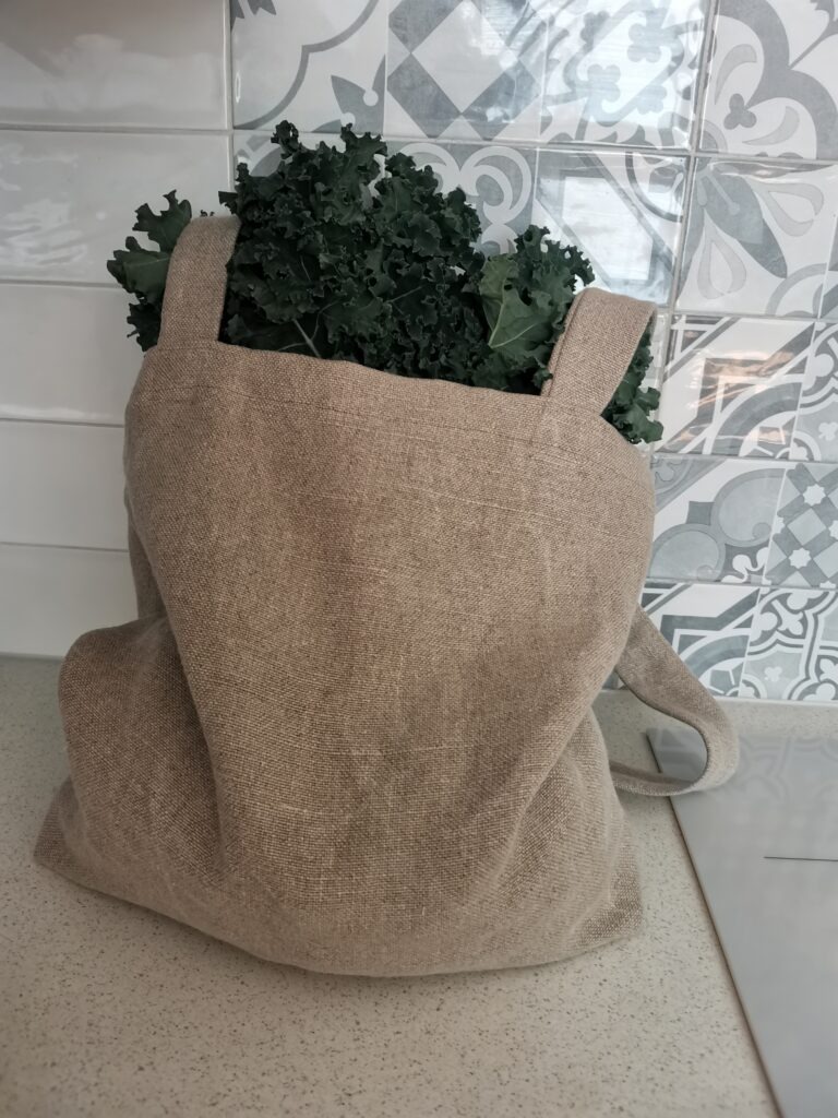 Torba lniana z pęczkiem jarmużu wewnątrz.